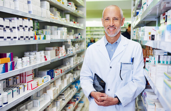 Portrait, pharmacist and senior man with tablet in aisle, healthcare and confidence with occupation. Face, employees and medical with professional, tech and retail with stock, smile and inventory
