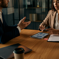 Man and Woman at Office Desk Discussing and Presenting a Project