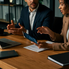 Man and Woman at Office Desk Discussing and Presenting a Project