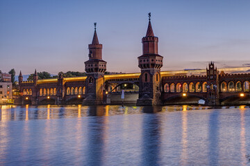 Naklejka premium The Oberbaumbruecke over the river Spree in Berlin after sunset with a motion blurred subway