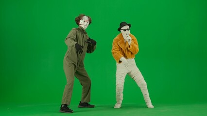 Portrait of person in a mummy bandage on chroma key green screen background. Mummy singing in karaoke microphone Maniac dancing with him.