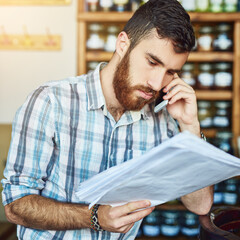 Man, phone call and shop owner in cafe with paperwork, thinking and reading for price, stock and deal. Barista, smartphone and documents for invoice, inventory and contact supplier in restaurant