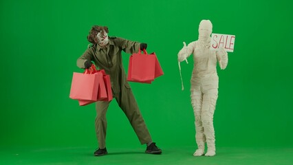 Portrait of person in mummy bandage on chroma key green screen background. Maniac with handful of...