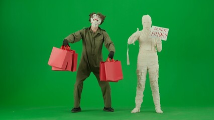 Portrait of person in mummy bandage on chroma key green screen background. Maniac with handful of...