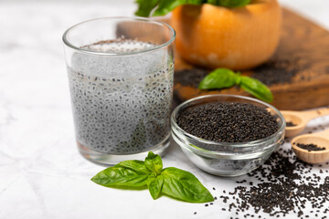 Basil seeds on textured wooden background. Close-up. Superfood. Ocimum basilicum. Organic basil seeds. selasih. Space for text. Copy space.