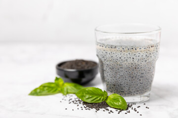 Basil water and basil seeds on textured wooden background. Close-up. Superfood. Ocimum basilicum. Organic basil seeds. selasih. Vegan drink. Space for text. Copy space.