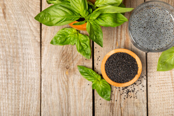 Basil seeds on textured wooden background. Close-up. Superfood. Ocimum basilicum. Organic basil seeds. selasih. Space for text. Copy space.