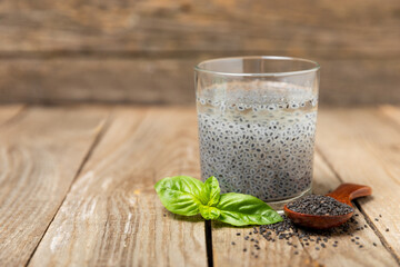 Basil water and basil seeds on textured wooden background. Close-up. Superfood. Ocimum basilicum....
