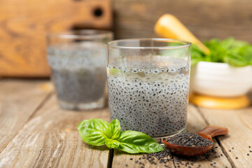Basil water and basil seeds on textured wooden background. Close-up. Superfood. Ocimum basilicum....