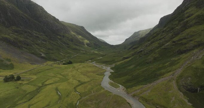 Aerial view of a beautiful winding river through a serene valley surrounded by majestic mountains, Kyle, United Kingdom.
