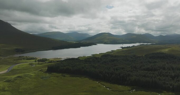 Aerial view of serene Loch Tulla surrounded by majestic mountains and lush forest, Bridge of Orchy, Scotland.
