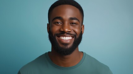 A man with a beard and a green shirt is smiling. He has a happy expression on his face