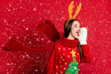 Photo of cheerful young woman look say news empty space wear scarf gloves deer headband isolated on red color background