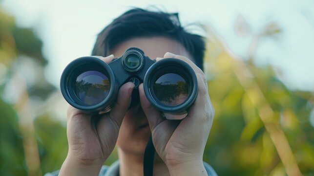 A man using binoculars to observe the surroundings.