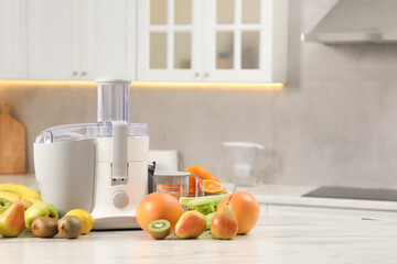 Modern juicer and fruits on white marble table in kitchen, space for text