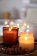 Burning candles and decor on tray indoors, closeup. Autumn atmosphere