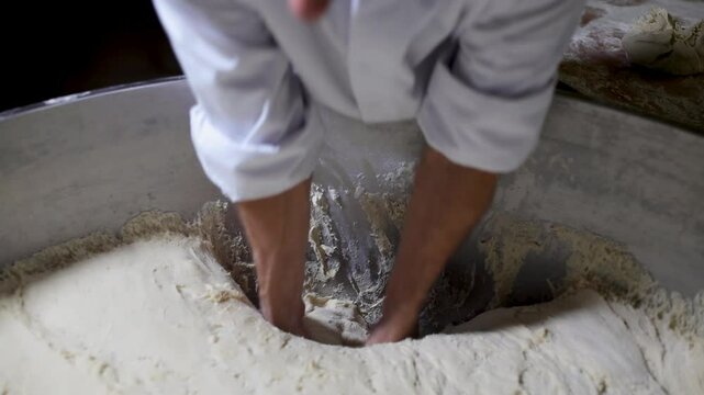 Baker removing dough from mixer bowl and placing it on the worktable for shaping