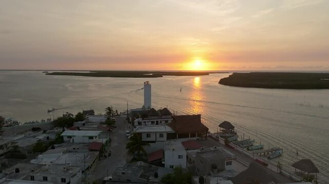 Aerial view of picturesque coastal town at sunset with lighthouse and tranquil water, Progreso, Mexico.