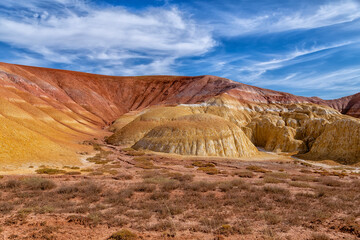 Akzhar Ulytau chalk mountains in the desert of Kazakhstan. Rare sandy hills with many multi-colored layers of clay, sand, chalk and gravel of bizarre shape far from civilization with sparse vegetation