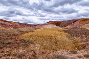 Akzhar Ulytau chalk mountains in the desert of Kazakhstan. Rare sandy hills with many multi-colored layers of clay, sand, chalk and gravel of bizarre shape far from civilization with sparse vegetation