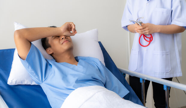 Aching Discomfort: A young male patient winces in pain, seeking relief from a compassionate nurse in a sterile hospital setting.