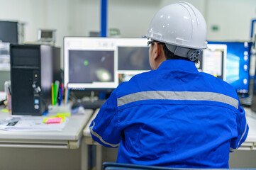 Computer engineers developing software programs to control industrial machinery,optimizing automation processes,and improving production flow in a high-tech factory setting