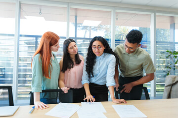 Four business office colleagues reviewing important documents standing together in a professional...