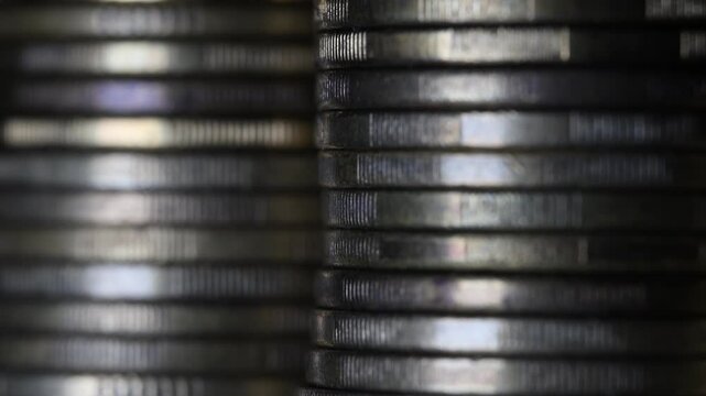 Stack of brown coins in close-up, texture of old coins, dark background, focus moving 