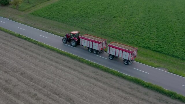 Bern, Switzerland - 01 August 2024: Aerial view of farmland with a tractor digging potatoes using a Ropa Keiler, Bern, Switzerland.