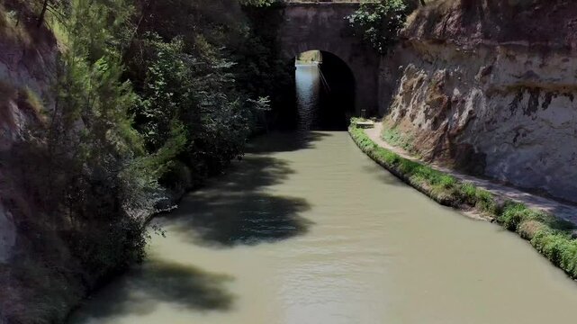 Aerial view of the scenic tunnel of Malpas for ships surrounded by tranquil waterway and lush foliage, Aude, France.