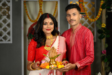 Portrait of a man dressed in kurta pyjama stands alongside a beautiful Indian woman wearing...