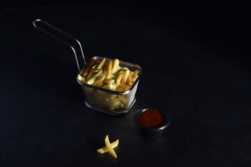 French fries served in a metallic mesh frying basket shaped recipient with three sauce varieties - dark background, camera slide parallax