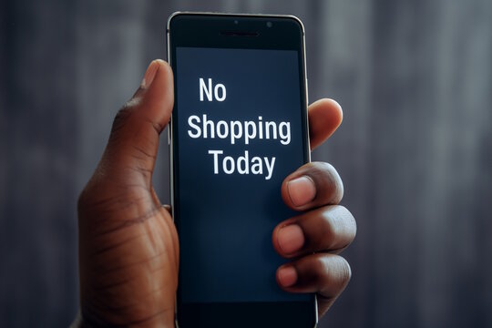 African american male hand holding smartphone with "No Shopping Today" message on the screen. Concept of minimalism, conscious consumerism, Buy Nothing Day