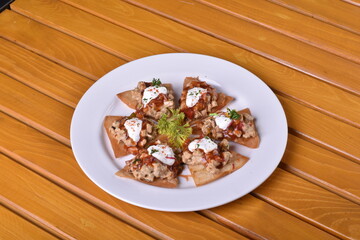 Mexican nacho chips baked with chicken, black beans and cheese on a plate top view