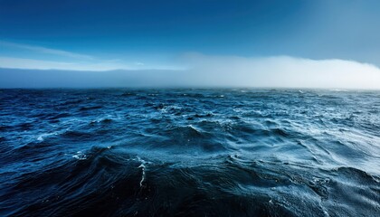 Serene Ocean Horizon at Dawn. Calm Blue Waters Meeting a Clear Sky with Gentle Dark Mist Rolling Over Distant Mountains, Creating a Peaceful and Expansive Coastal Scene in Early Morning Light