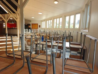 Upside-down chairs on tables in a hall, non-residential space