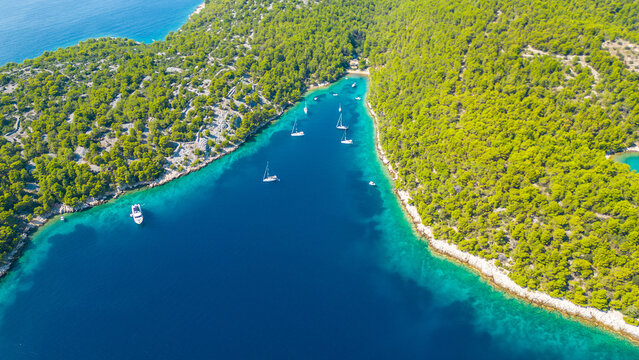 An aerial view of the beautiful beach on Zlarin Island, Croatia. This quiet beach, surrounded by lush greenery and crystal-clear waters, offers a peaceful retreat for visitors
