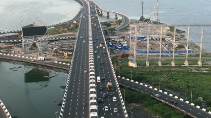 Aerial view of vibrant urban landscape with a bustling bridge over a river and modern buildings, Lagos Island, Nigeria.