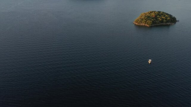 Aerial view of serene coastline with picturesque small island and tranquil blue water, Nydri, Greece.