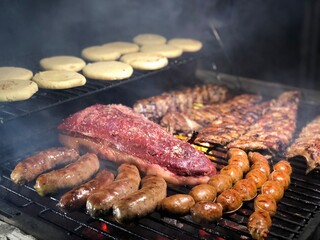 a barbecue with different types of proteins and arepas