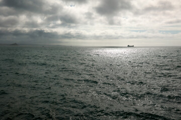 Obraz premium A boat in the distance at sunrise, Penzance, Cornwall, UK