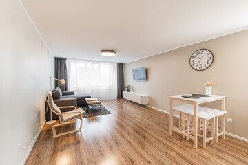 Modern Home Living Room and Windows. Stylish Modern Apartment. Open Interior, Stylish Sofa, Couch, TV Screen, Hardwood Floor and Old Retro Style Clock on the Wall. Dining Table.