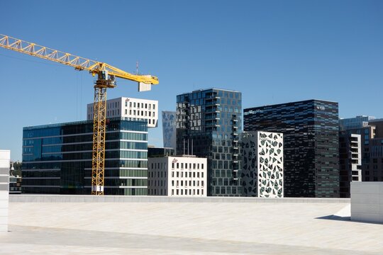 Modern skyscrapers in Oslo with KLP, Deloitte or Visma companies. Industrial crane, construction of new one