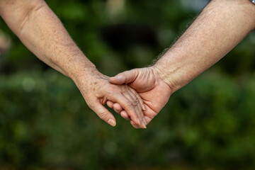 The hands of an elderly couple who have carried love and tenderness through life.