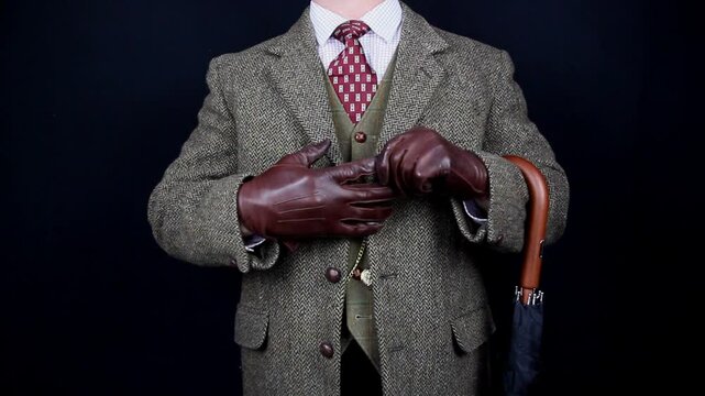 English Gentleman in Tweed Suit Taking off Brown Leather Gloves. Vintage Style and Retro Fashion.