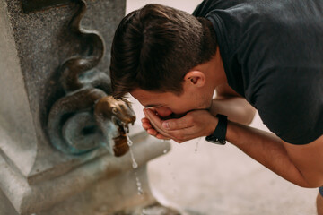 A man drinks water from a mineral spring in Karlovy Vary. A man tries the water from a thermal...