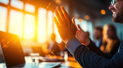 A diverse group of people clapping in an office setting during a successful meeting, illuminated by warm sunlight from large windows.