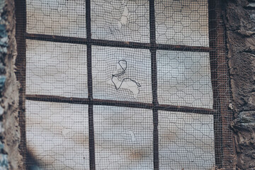 Wire fence or metal net on sunset background, blue sky. hole in old net.