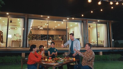 Happy family holding glowed sparkler in holiday celebration party at night. Lovely member enjoy playing spark toy together. Outdoor activity to cross generation gap strengthen family bond. Divergence.