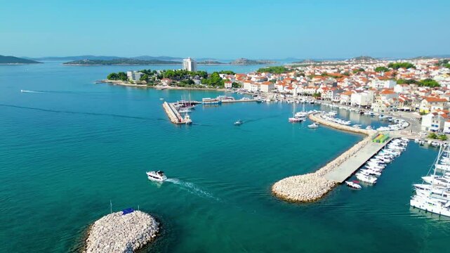 Vodice, a charming coastal town in Croatia, captured from the air. The turquoise waters of the Adriatic Sea surround the vibrant town, known for its beautiful beaches, bustling marina